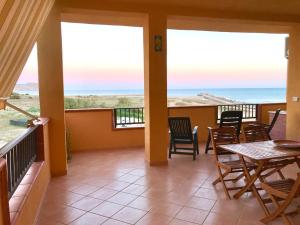 een balkon met een tafel en stoelen en de oceaan bij La Terrazza sul Mare in Siculiana Marina