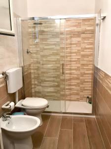 een badkamer met een toilet en een glazen douche bij La Terrazza sul Mare in Siculiana Marina