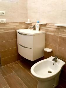 een badkamer met een witte wastafel en een toilet bij La Terrazza sul Mare in Siculiana Marina