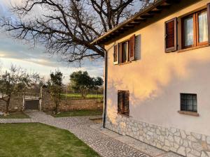 a house with a stone wall next to a yard at Casa Vacanze Nonna Vittoria in Spoleto