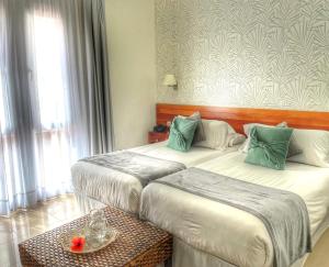 a hotel room with two beds and a table at Balneario Pozo de la Salud in Sabinosa +21 photos