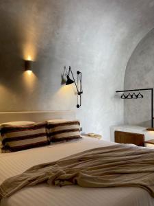 a bedroom with a bed and a desk with a bed at Aethra Cave Suites in Pyrgos