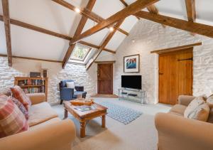 a living room with a stone wall at Corn Loft in Solva