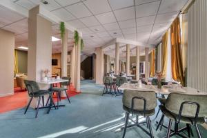 a restaurant with tables and chairs in a room at Cit'Hotel L'ESCURIAL - Centre Gare in Metz