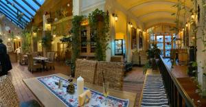 シギショアラにあるPensiunea Gasthaus Alte Postの建物内のテーブルと椅子のあるレストラン
