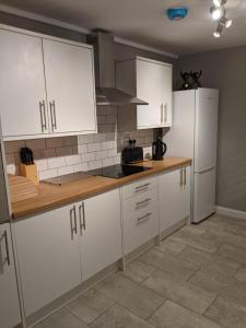 a kitchen with white cabinets and a counter top at *Feel at home* 3bed 2bath house Cleethorpes in Grimsby