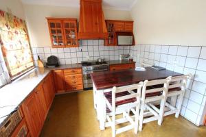 a kitchen with wooden cabinets and a table and chairs at Figtree Lane Lodge in Richards Bay