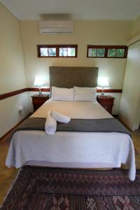 a bedroom with a large bed with two lamps at Figtree Lane Lodge in Richards Bay