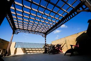 a building with awning and benches in front of a wall at Villa Getaway with Private Pool in Sannat