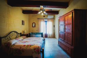 um quarto com uma cama e uma ventoinha de tecto em Villa Getaway with Private Pool em Sannat