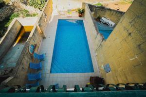an overhead view of a swimming pool with blue chairs at Villa Getaway with Private Pool in Sannat