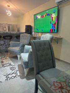 sala de estar con sillas y TV de pantalla plana en Curasita colour Appartments en Willemstad