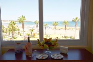 a table with a view of the beach from a window at ADMİRAL HOTEL in Kizkalesi