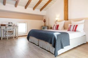 a bedroom with a bed with a blue blanket and a table at Hotel La Maison Oppoca in Aïnhoa