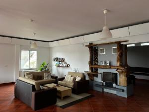 ein Wohnzimmer mit einem Sofa und einem Kamin in der Unterkunft Casa Os Manos in Santana