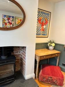 a living room with a table and a fireplace at Spring Crescent Cottage in Rye in Rye