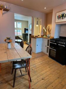 a kitchen with a wooden table and a dining room at Spring Crescent Cottage in Rye in Rye
