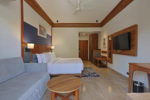 une chambre d'hôtel avec un lit et un canapé dans l'établissement VOCO Jim Corbett, an IHG Hotel, à Rāmnagar