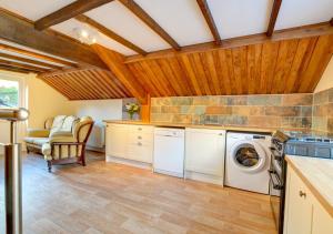 a kitchen with a washer and dryer in a room at Tynddol Isaf in Pentre-briwnant