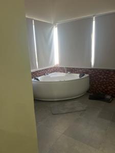 a white bath tub in a room with a window at Curasita colour Appartments in Willemstad