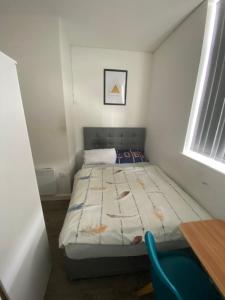 a small bedroom with a bed and a window at Cozy, comfortable bedroom in a shared flat, within a walking distance of the train station in Wigan Town Centre in Wigan