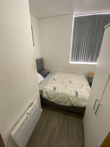 a small bedroom with a bed and a window at Cozy, comfortable bedroom in a shared flat, within a walking distance of the train station in Wigan Town Centre in Wigan