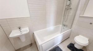 a bathroom with a sink and a toilet and a bath tub at Cozy, comfortable bedroom in a shared flat, within a walking distance of the train station in Wigan Town Centre in Wigan
