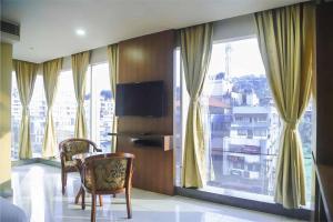 una camera con tavolo, sedie e finestre di HOTEL APOLLO GRAND A UNIT OF SATYAM ASSOCIATES a Guwahati