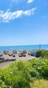 a view of a parking lot with cars and the ocean at Amazing Sea View Chalet. 1 minute from the sea , harbour and Cobb and very nr to fabulous pubs , restaurants and activities. Sleeps 4 with parking in Lyme Regis