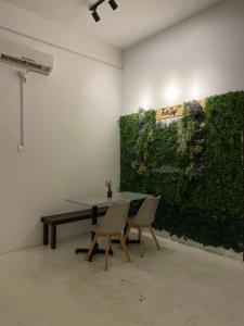 a table and chairs in a room with a green wall at Two Sip Home in George Town