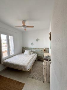 een slaapkamer met een bed en een plafondventilator bij Mar i Vent in Cala Blanca