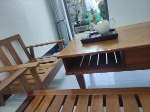 a wooden table with a chair and a vase on it at NEW WAVE HOMESTAY in Ấp Khánh Phước (1)