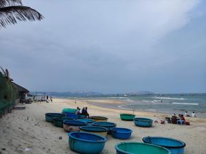 un groupe de bateaux bleus bordés sur une plage dans l'établissement NEW WAVE HOMESTAY, à Ấp Khánh Phước (1)