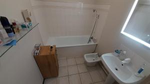 a bathroom with a sink and a tub and a toilet at Comfy Appartement 85m2 in a calm area in Montreuil 10min from Paris in Montreuil +10 photos