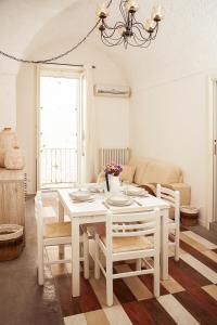 un tavolo bianco e sedie in soggiorno di Casa Vita Lenta by Momò Apulia a Monopoli