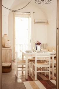 una sala da pranzo bianca con tavolo e sedie bianchi di Casa Vita Lenta by Momò Apulia a Monopoli