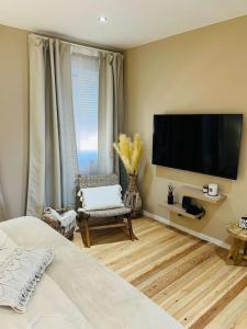 Schlafzimmer mit einem Bett und einem Flachbild-TV in der Unterkunft Appartement bohème avec bain balnéo in Lüttich