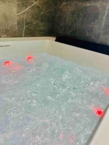 une baignoire remplie d'eau avec des bulles rouges dans l'établissement Appartement bohème avec bain balnéo, à Liège