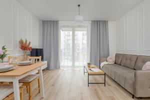 een woonkamer met een bank en een tafel bij Cozy Apartment Orawska with Balcony by Renters in Krakau