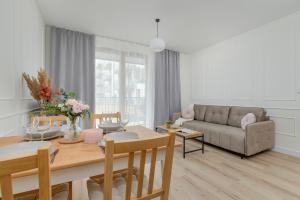 un soggiorno con un tavolo e un divano di Cozy Apartment Orawska with Balcony by Noclegi Renters a Cracovia