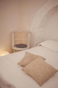 una camera con letto e sedia in rattan di Casa Vita Lenta by Momò Apulia a Monopoli