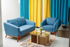 2 blaue Stühle und ein Couchtisch im Wohnzimmer in der Unterkunft Modern Village Apartments in Chipata