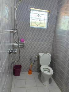 bagno con servizi igienici e finestra. di RESIDENCE LA VARENNE, DSCHANG a Dschang