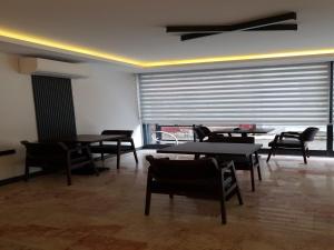 ein Esszimmer mit Tischen, Stühlen und einem Fenster in der Unterkunft Hotel Kriti in Antalya