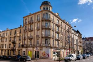 um edifício com uma torre de relógio em cima em Hôtel Escurial - Centre Gare em Metz