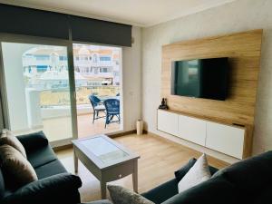 a living room with a couch and a flat screen tv at G&G Isla Marina Puerto 2 in Benalmádena