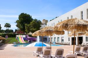 un complejo con sillas y sombrillas y una piscina en FERGUS Club Palmanova Park, en Palmanova