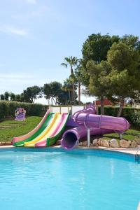 eine lila und farbenfrohe Wasserrutsche in einem Pool in der Unterkunft FERGUS Club Palmanova Park in Palmanova