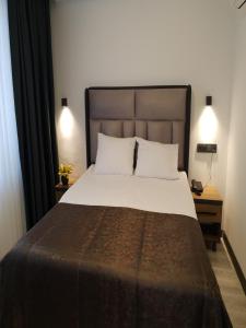 a bedroom with a large bed and two lamps at Hotel Kriti in Antalya