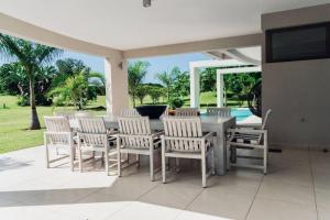 a patio with a table and chairs and a television at The Four Palms in Kilifi